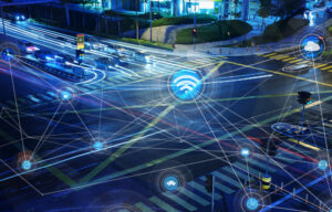Aerial view of a busy city intersection with digital icons representing connectivity and technology overlay.
