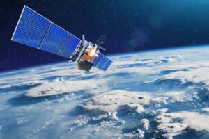 A satellite with blue solar panels orbits Earth, with clouds and a clear view of the planet's curvature below.