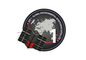 Satellite with solar panels in front of an Earth illustration, labeled "IOD-1 Global Environmental Monitoring Satellite.