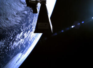 Satellite in orbit with Earth in the background, partially illuminated with visible clouds and oceans.