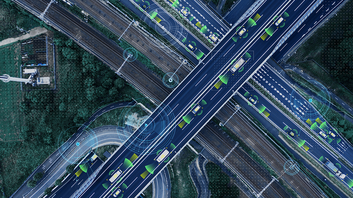 Aerial view of smart highway with autonomous vehicles highlighted by digital overlays.