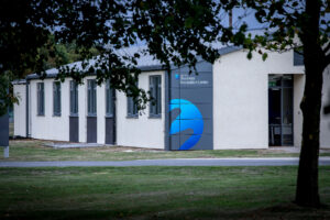 Building with sign reading "Business Incubation Centre," surrounded by trees and grass.