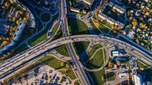 Aerial view of a complex highway interchange with looping roads and surrounding buildings.