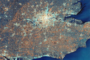 Satellite view of southeastern England at night, highlighting urban areas with bright lights and surrounding coastlines.