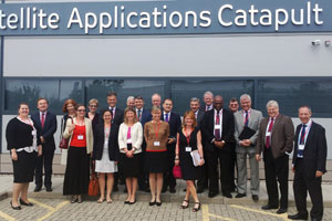 Group of people in business attire standing outside the Satellite Applications Catapult building.