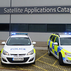 Two police cars parked in front of a building labeled "Satellite Applications Catapult.