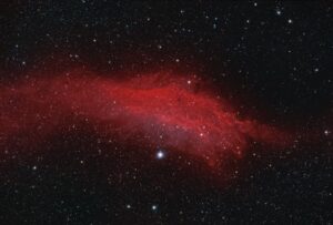 The image shows the bright red California Nebula against a backdrop of numerous stars in space.