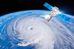 Satellite view of Earth showing a large hurricane swirling over the ocean, with clear skies around.