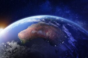 View of Earth from space with Australia prominently visible, surrounded by the dark expanse of space and a glowing horizon.