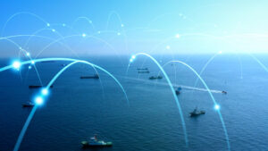 Ships on the ocean with digital connectivity lines arcing above, symbolizing networked maritime communication.