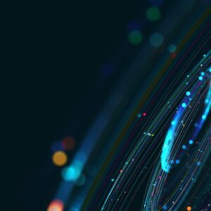 Abstract digital art with multicolored light trails and bokeh against a dark background.