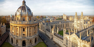 Panoramic view of Radcliffe Camera and surrounding historic buildings in Oxford, under a clear sky.