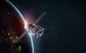 A satellite orbiting Earth with bright lights visible on the planet's surface against a starry background.