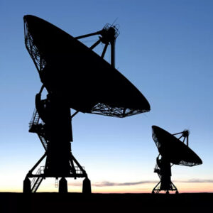 Silhouetted large radio telescopes against a clear dusk sky, capturing signals from space.