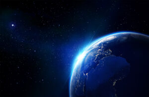 Earth from space with glowing sunrise, visible continents, and starry background.