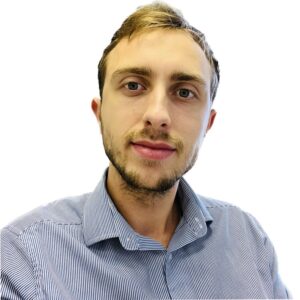 Man with short hair and a beard wearing a striped shirt, looking at the camera against a white background.