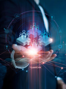 A person holds a 3D hologram of puzzle pieces and people, symbolizing teamwork, with digital icons around.