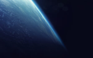 A view of Earth from space, showing a thin, bright blue atmospheric layer against the dark backdrop of space.