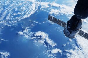 Satellite orbiting above Earth with ocean and cloud formations visible in the background.