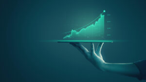 A hand holding a tablet projecting a glowing green upward graph, symbolizing growth and success.