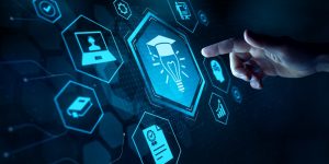 Hand pointing at digital education icons in a hexagonal interface, featuring a graduate cap and lightbulb symbol.