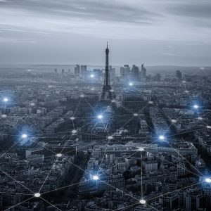 Aerial view of Paris with the Eiffel Tower and digital network lines and nodes superimposed over the cityscape.