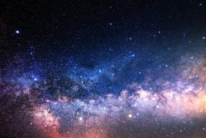 Starry night sky with a dense cluster of stars and a visible band of the Milky Way galaxy across the center.