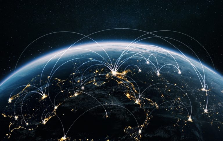 A view of Earth from space at night with bright city lights and white lines depicting network connections across continents.