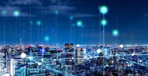 City skyline at night with digital network lines and glowing data points over the buildings.