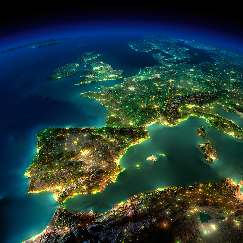 A view of Western Europe at night from space, showing city lights glowing across countries.