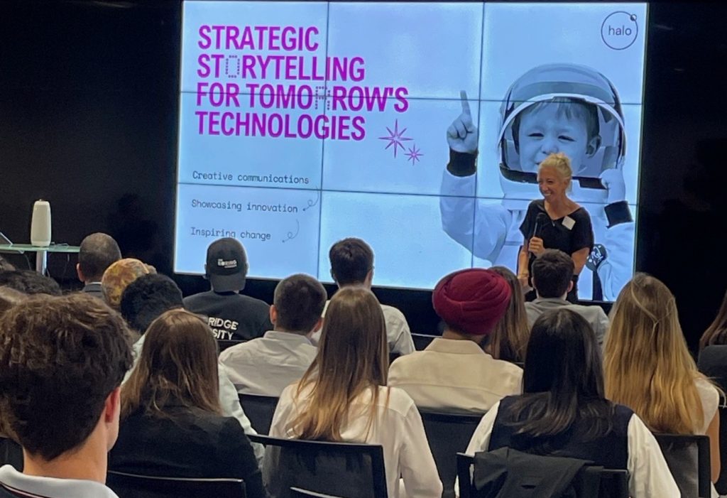A woman presents "Strategic Storytelling for Tomorrow's Technologies" to an audience in a modern classroom.