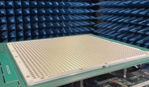 A close-up of a grid-like electronic device in a blue anechoic chamber for signal testing.