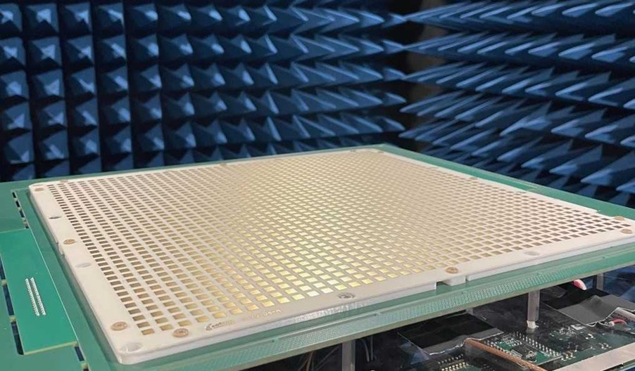 A close-up of a grid-like electronic device in a blue anechoic chamber for signal testing.