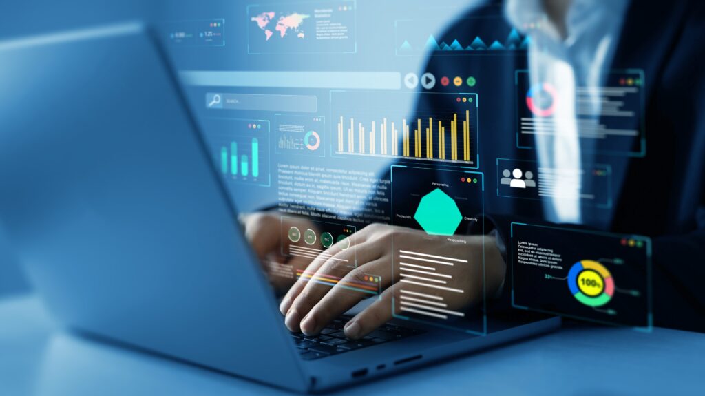 Person typing on a laptop with virtual data analytics dashboards and graphs displayed in front of the screen.