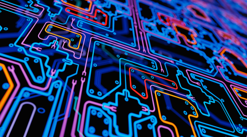Colorful, glowing circuitry lines forming a complex electronic pattern on a dark background.