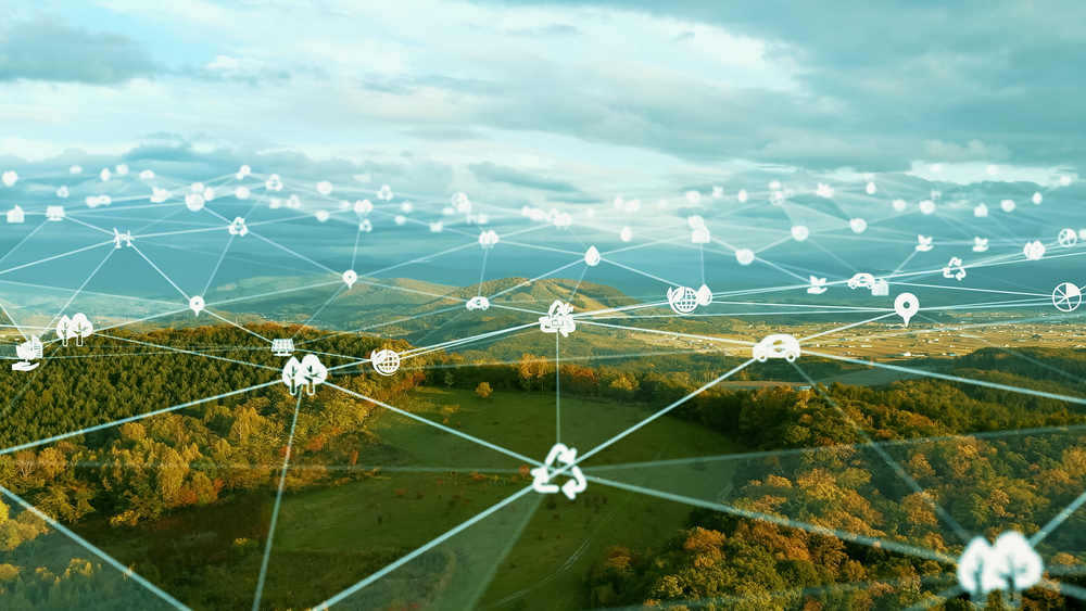 Digital network icons overlay a green landscape, symbolizing environmental technology and connectivity.