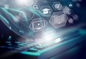 Fingers typing on a laptop keyboard with digital education and technology icons overlayed.