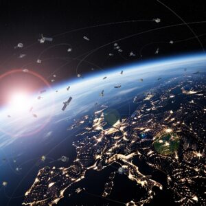 Satellites orbit Earth's surface above a sunlit Europe at night, with city lights and sunrise in the background.