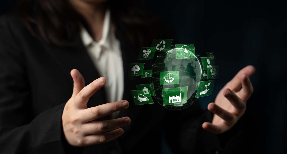 Person in a suit with hands around floating eco-friendly icons and a digital globe on a dark background.