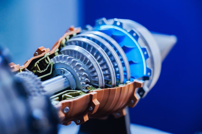 Close-up of a cutaway model of a jet engine showing metal turbine blades and internal components.