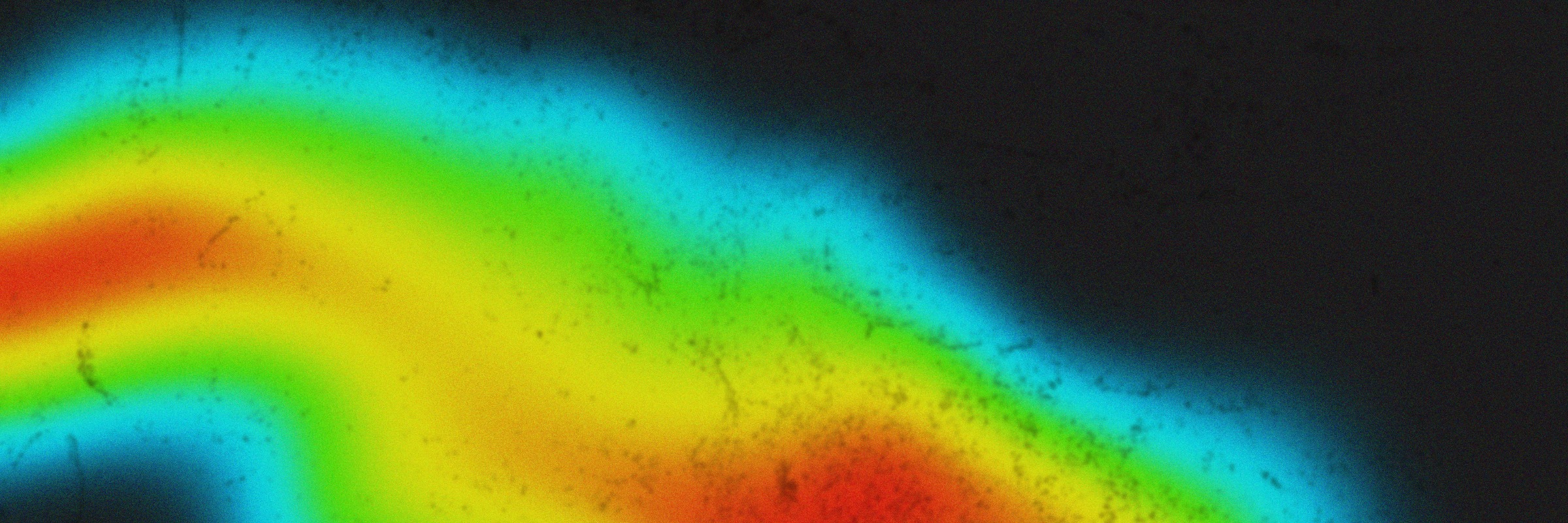 A colorful heat map gradient with blue, green, yellow, and red on a black background.