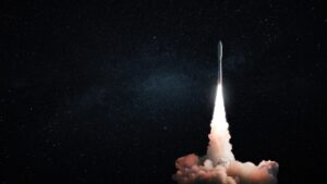A rocket launches into a starry night sky, leaving a trail of smoke and fire behind it.