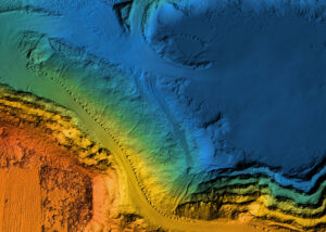 Colorful topographic map showing terrain elevations, with blues for low areas and oranges for higher ground.