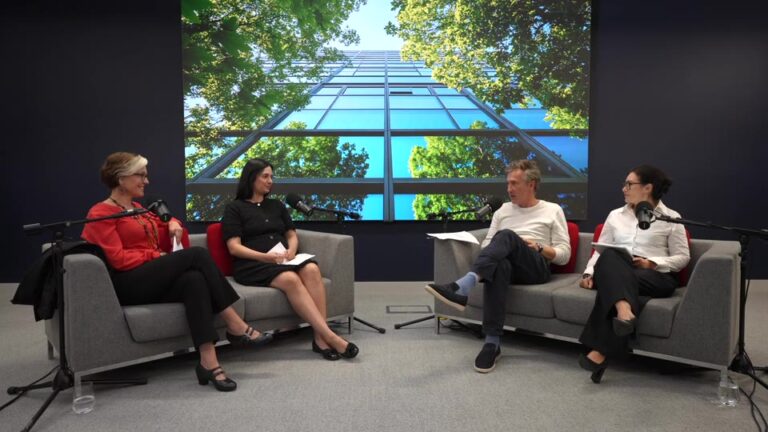 Four people sit on two facing sofas in a studio, participating in a podcast interview.